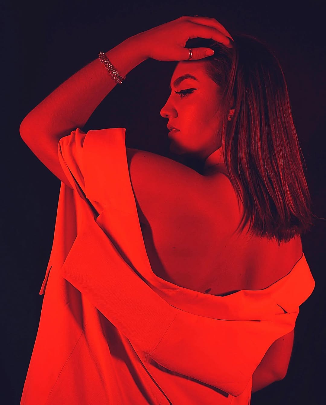 Retrato artístico de una mujer con iluminación roja en estudio de fotografía