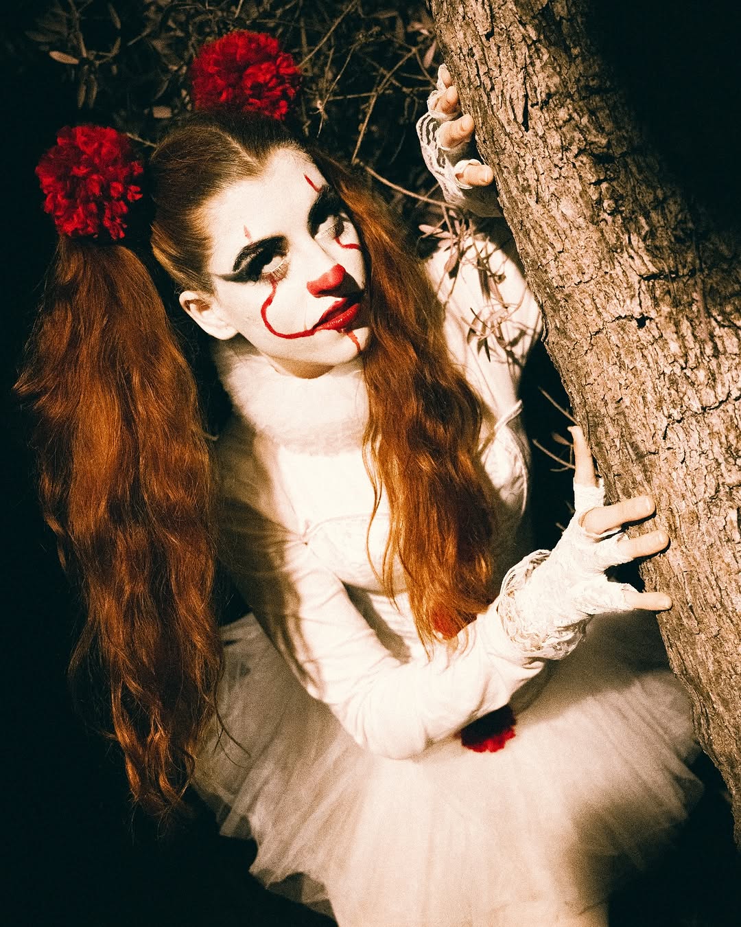 Mujer maquillada y vestida como personaje artístico en una sesión fotográfica nocturna.